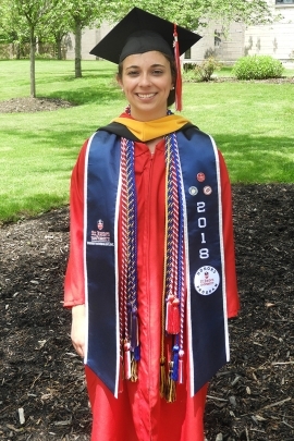 Jacqueline Canino standing outside in graduation cap and gown with cords