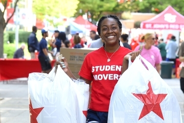 Female student mover holding two shopping bags