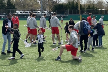 St. John's lacrosse players interacting with special needs students on the field