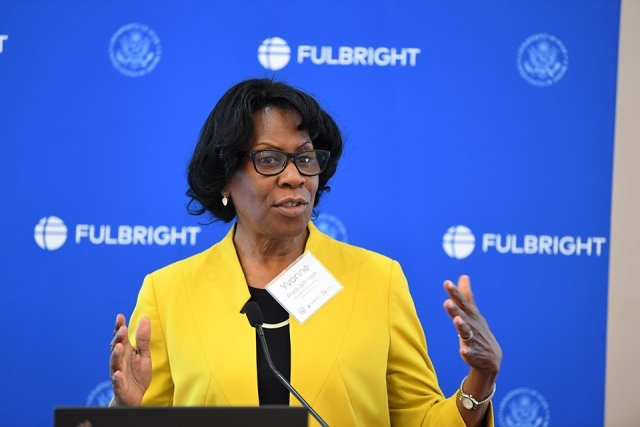 Yvonne Pratt Johnson speaking at podium with Fulbright banner behind her