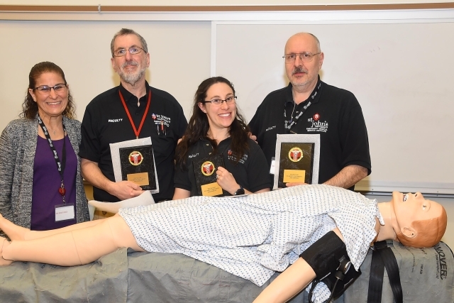 Inaugural Simulation Contest winners holding plaques