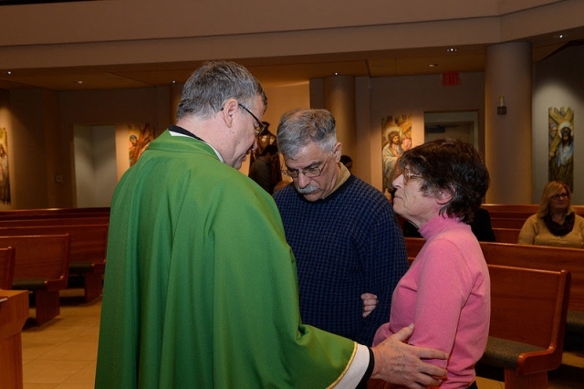 Alumni couple being blessed by Fr. Griffin during The Blessing of the Couples event