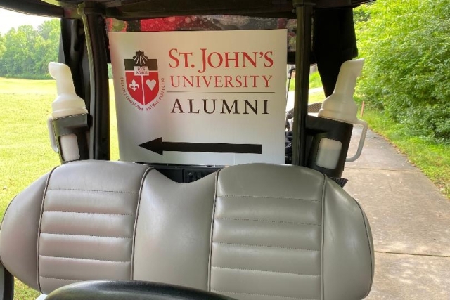 St. John's University Alumni poster on a golf cart