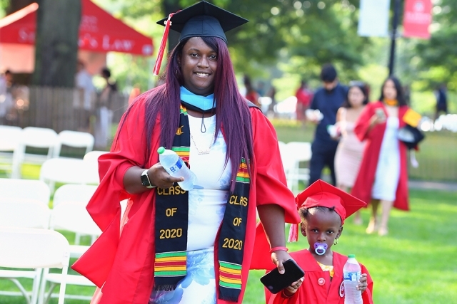 Graduate and her child, both dressed in grad gowns
