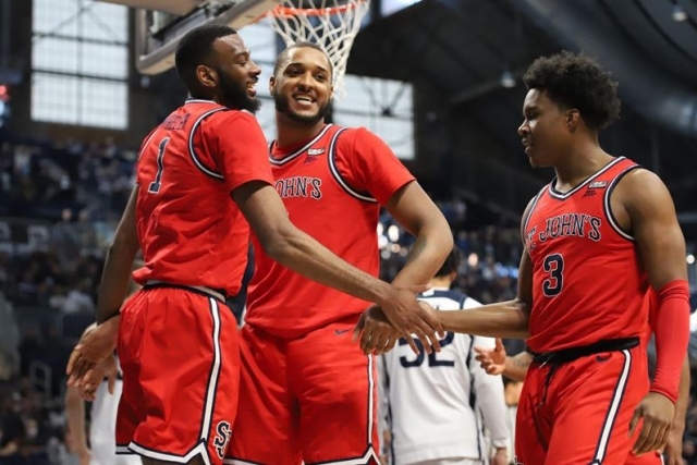 Three St. John's Men's Basketball players celebrating a victory