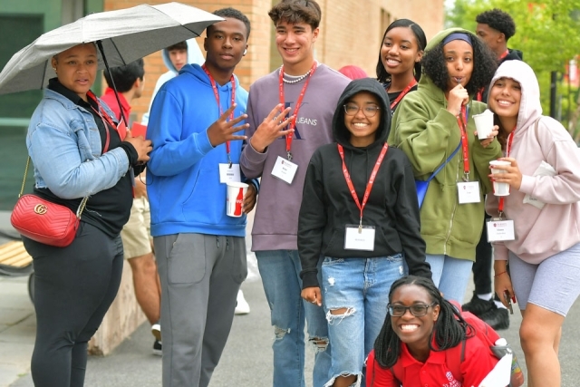 a group of students and a couple other individuals pose for a photo