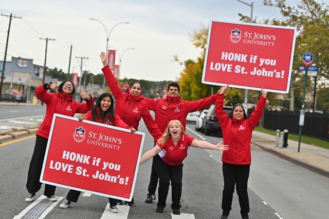Admissions ambassadors holding up "honk if you love St. John's" signs