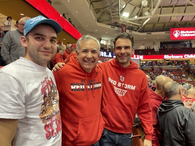St. John's Law alumnus Bob Gunther and two of his sons in the stands at a St. John's basketball game.