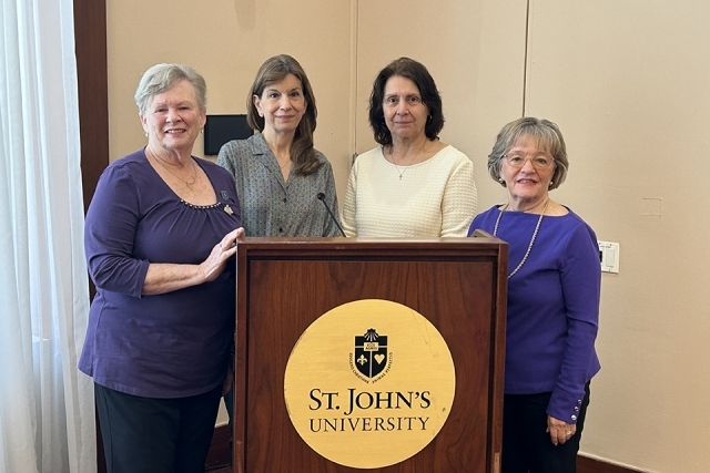 Four women standing at St. John's podium