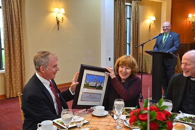 Kellehers holding framed plaque at a table