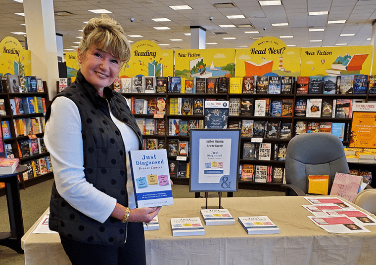 Arlene M. Karole holding her book "Just Diagnosed" inside a bookstore
