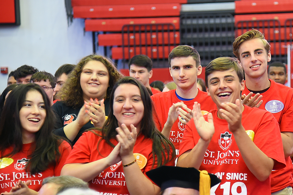 Group of students sitting at ceremony clapping