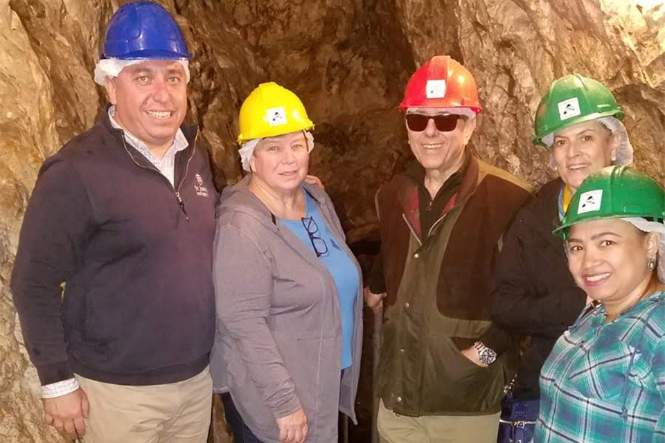 Mark Andrews and alumni/guests wearing hard hats