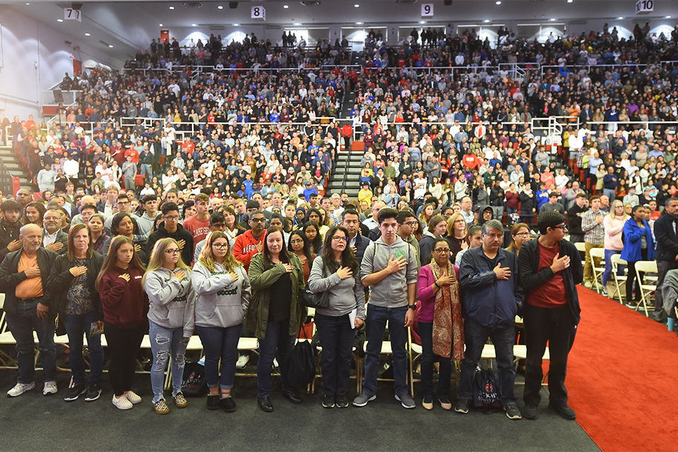 Welcome program crowd singing National Anthem