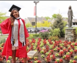 Sameera Ramjan poses for a picture near flowerbed