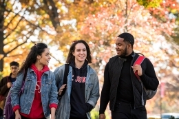Three students walking outside during a fall day