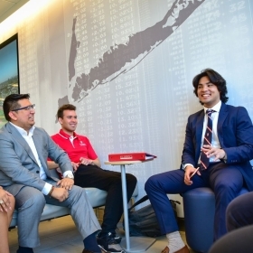 Students talking to a professor in The Peter J. Tobin College of Business building on St. John’s University campus