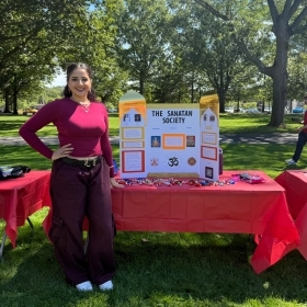 St. John's University student standing in front of an activties booth 