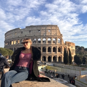 girl sitting in from of monumental roman architecture 