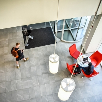 Overhead shot of students sitting and walking through lobby
