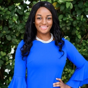 Black female entrepreneur standing in a blue dress 