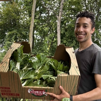 Lucas Shears carrying a carton of lettuce