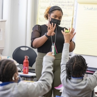 Black educator and entrepeneur teaching a class of young children 