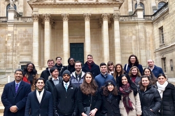 Students posing for a photo infront of columns