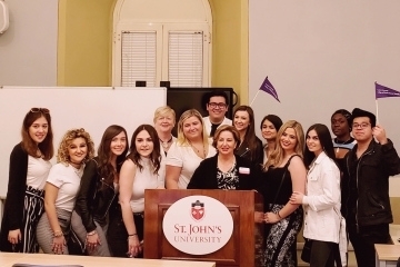 Students standing infront of St. John's University podium 