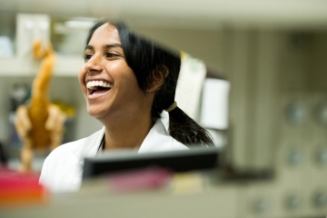 Female Student Laughing in Lab Coat
