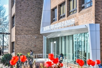 Front of the Peter J Tobin College of Business with flowers blooming