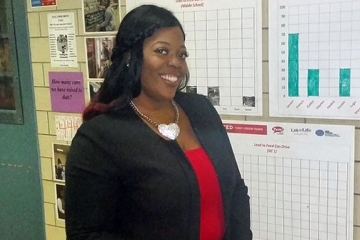 Latasha Jones stands in front of graphs
