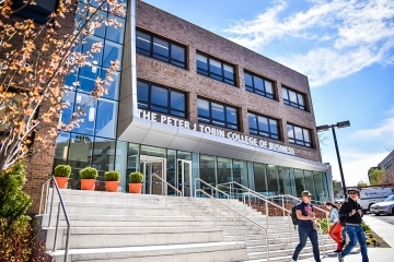 Exterior of the Peter J Tobin College of Business building with students walking outside