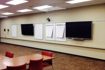 Wall with tv screens and white postit boards