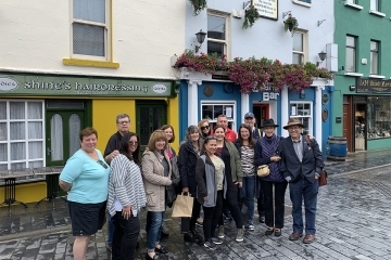 Alumni and Friends in Ireland in front of storefronts 