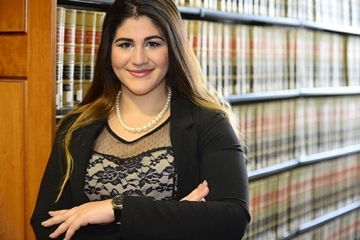 Donya Nasser in front of shelves of books