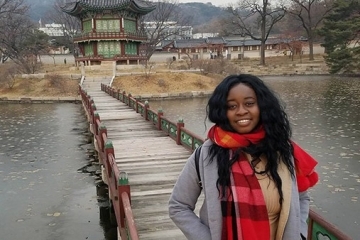 Emmanuella Bonga Bikele in front of a bridge over a river