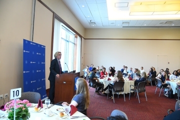 Simon speaking to audience from podium