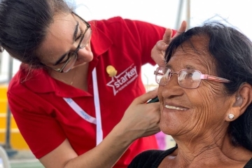 Audiology student checking Peruvian woman's ear
