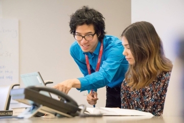 Raymond Pun pointing to computer of student