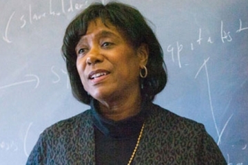 Dr. Joan Tropnas in front of a chalkboard