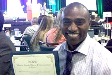 Eric James '11C holding up an award
