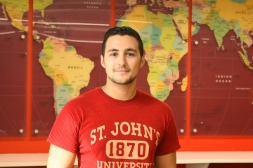 JohnAnthony DiMaria standing in front of world map
