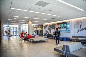 student looking at TV in tobin lobby