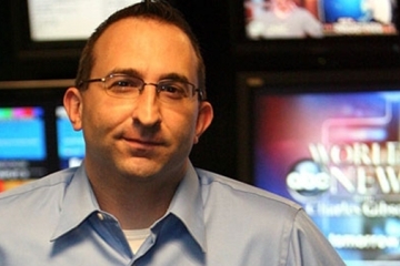 Roy Garlisi '92SVC in front of tv monitors