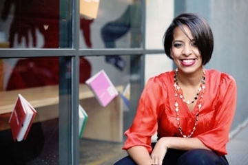 Soribel Genao, Ph.D. ’03CPS outside a window with books hanging up
