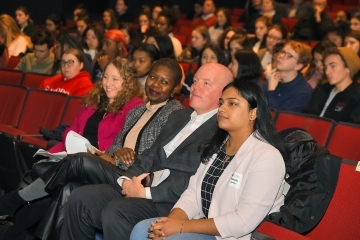 Kevin Ryan sitting in seat with lecture attendees in Little Theatre