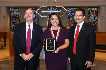 Michelle Amaryllis Centeno holding a plaque at Vincentian Convocation