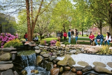 Students hanging out around water fountain