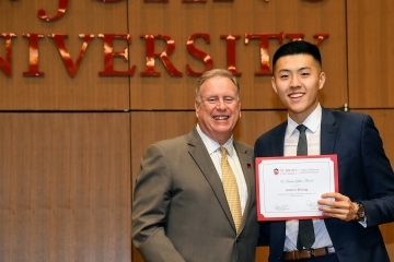 Andrew Kwong  on stage with Dean DiGate to receive award